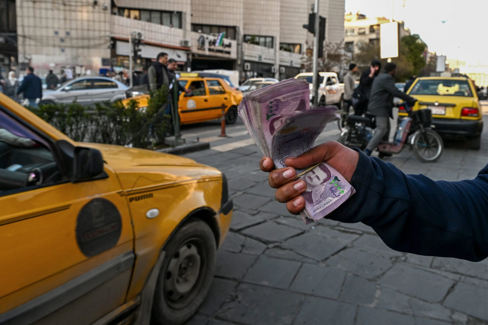 A currency trader offers Syrian liras