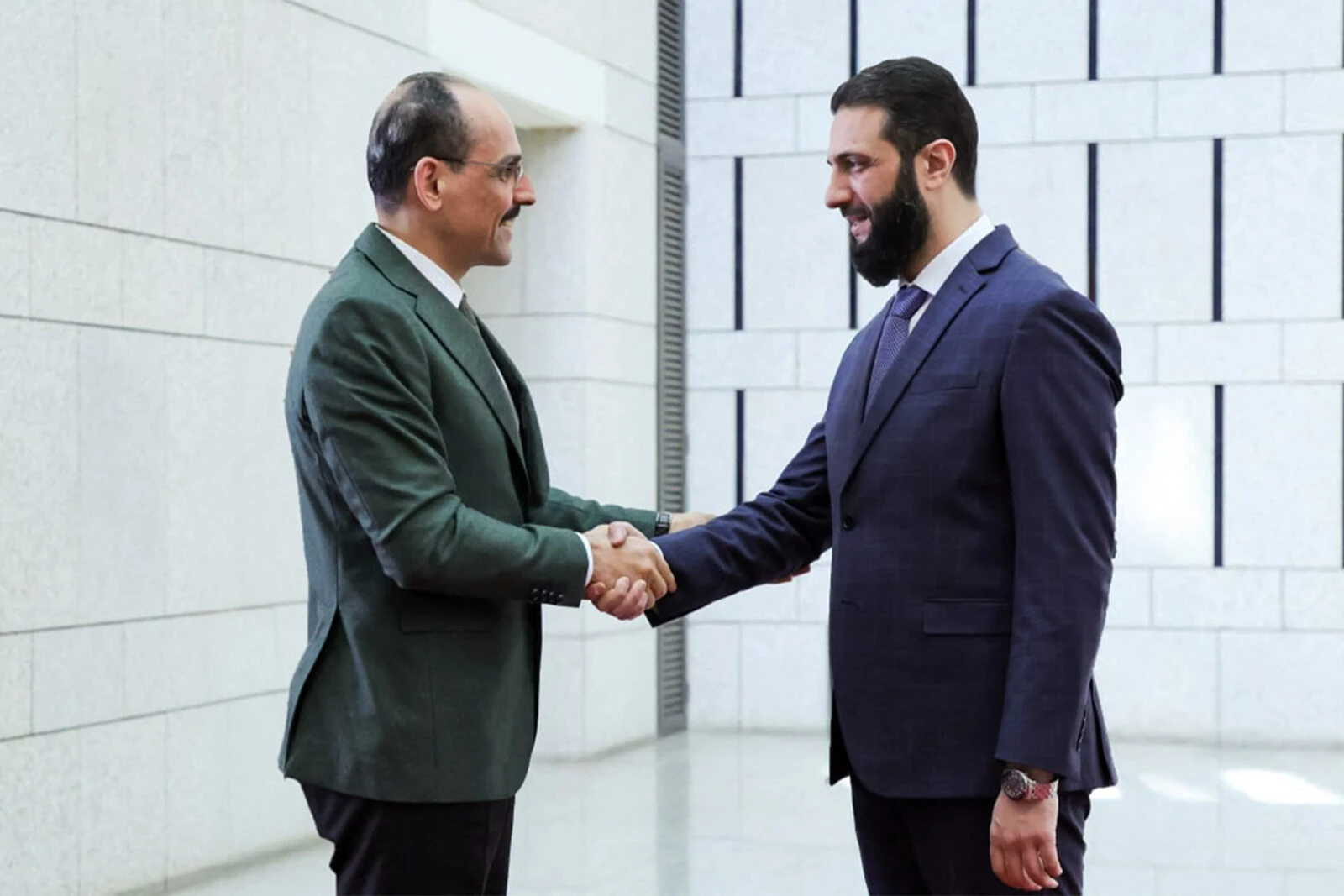 Syria's interim leader Ahmed al-Sharaa (R) receiving the director of Turkey's National Intelligence Organization (MIT) Ibrahim Kalin handshake