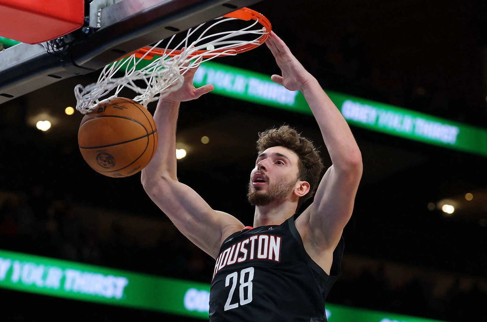 Photo shows Houston Rockets' Alperen Sengun, wearing a black jersey, dunking