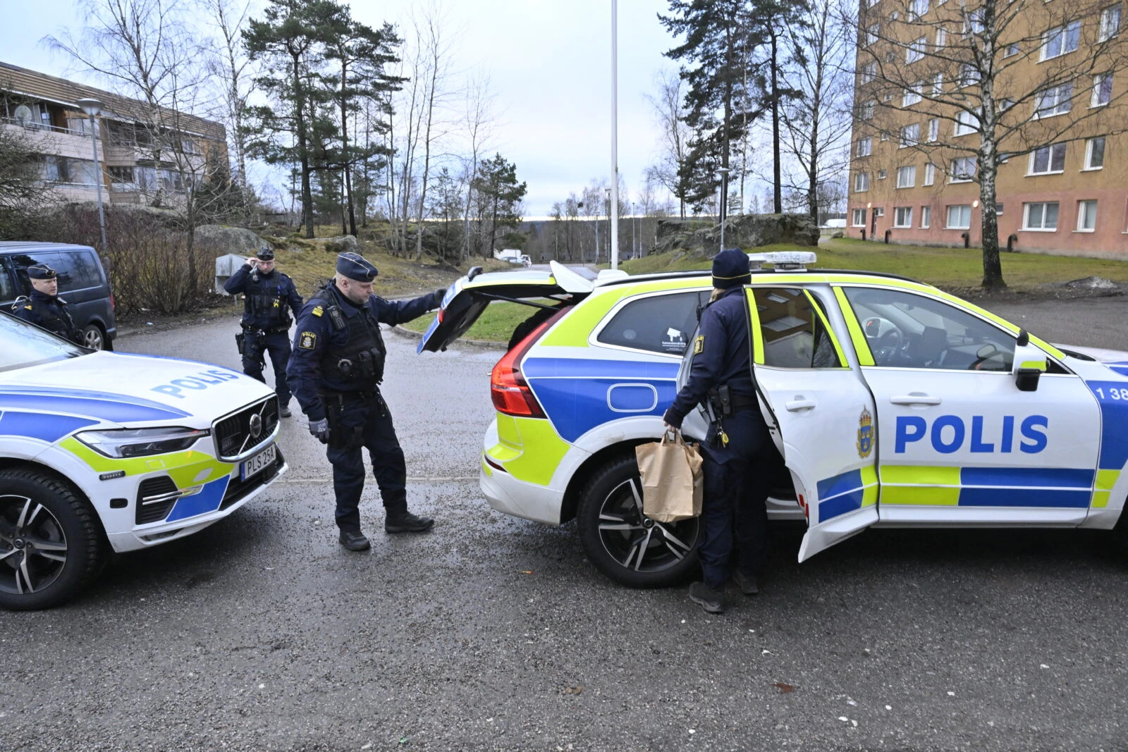 Policemen stand outside an apartment building in Södertälje, Sweden