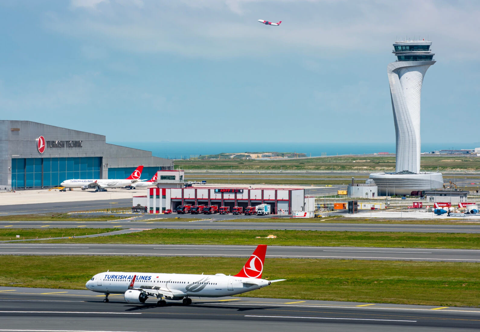 File photo shows a Turkish Airlines aircraft taxiing on the runway at Istanbul Airport, with the air traffic control tower and Turkish Technic maintenance hangar in the background. (Adobe Stock Photo)