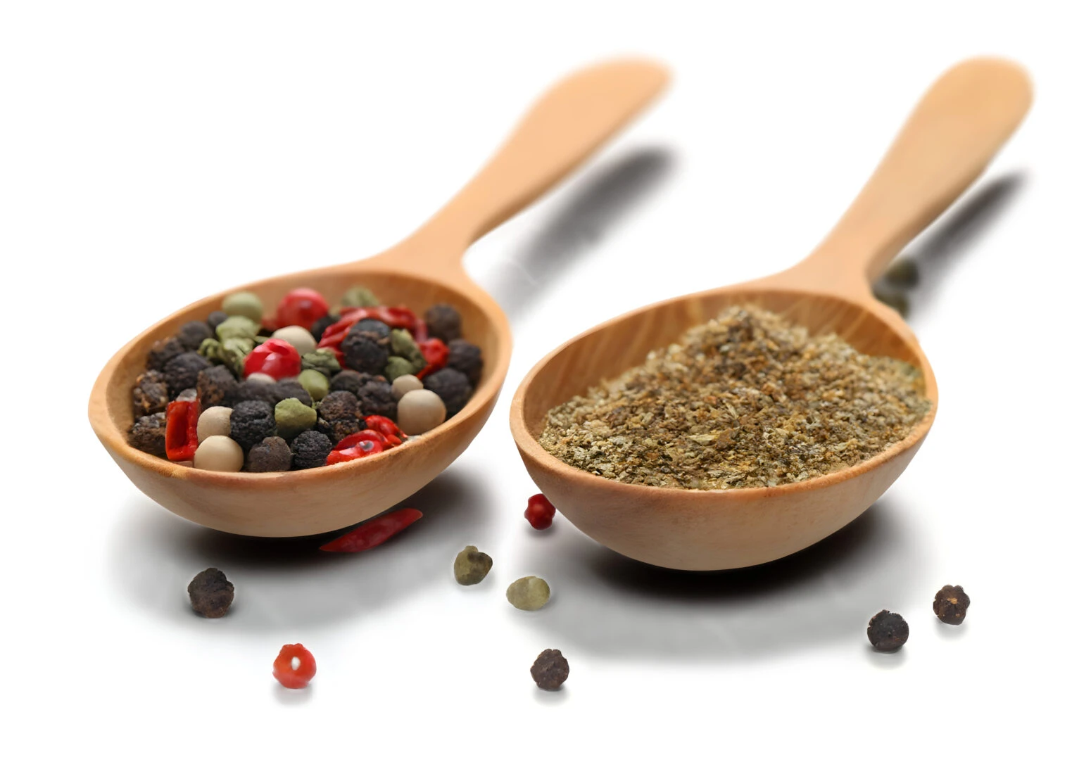 Two wooden spoon filled with various spices on a white background, isolated for clear visibility.