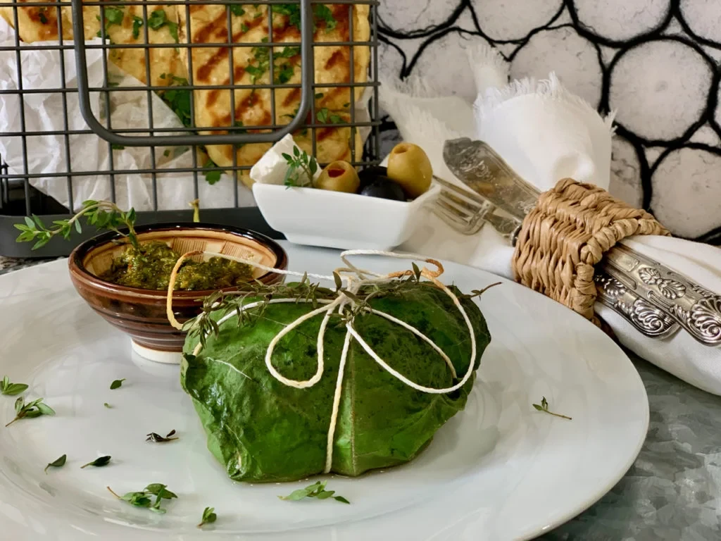 A piece of palamut fish wrapped in fig leaves, ready for cooking. bonito recipe