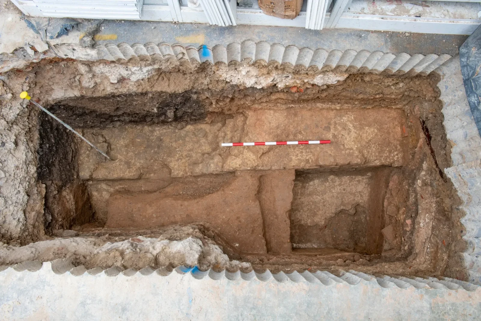 Archaeological test pit exposing ancient Roman walls, uncovered during excavations.