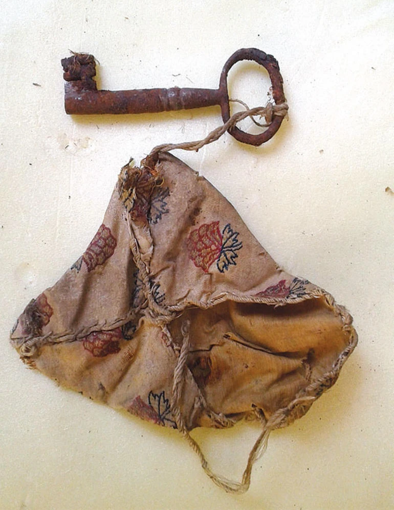 A historic Ottoman-era amulet with an attached key, uncovered during restoration work at Topkapi Palace.