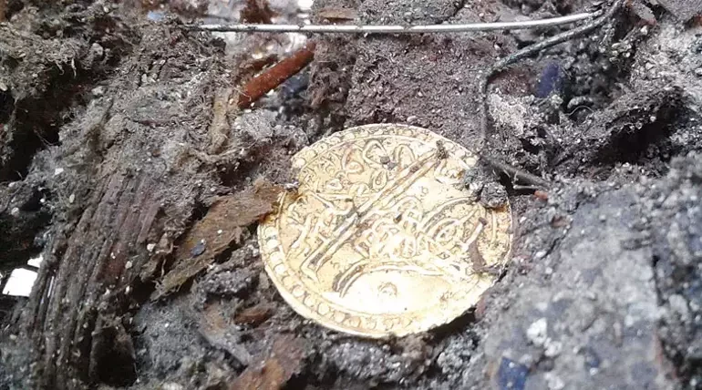 A gold coin from the reign of Sultan Mahmud II, uncovered during restoration at Topkapı Palace, displayed in detail.