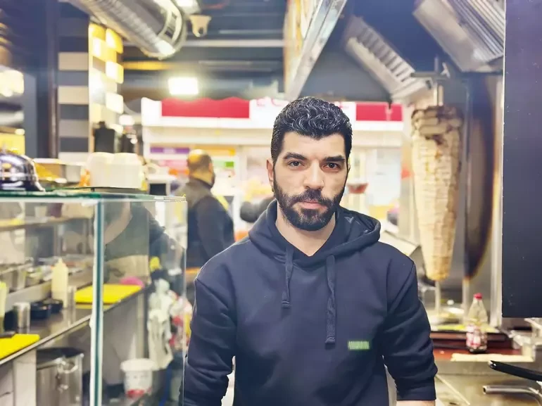 Ayman Khalil, a 30-year-old employee at Toşka Restaurant in Istanbul, Türkiye, standing in the restaurant.