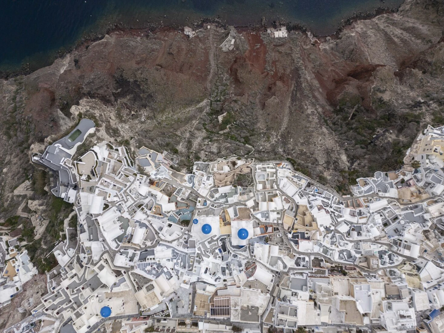 A drone view of the Blue Domed Church and the surrounding village of Oia, Santorini. santorini earthquakes