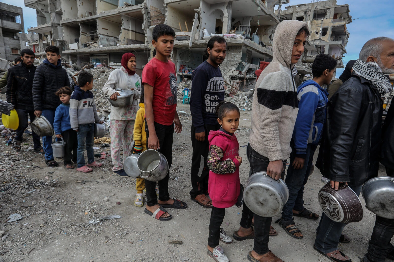 Photo shows Palestinians receiving food distributed by volunteers.