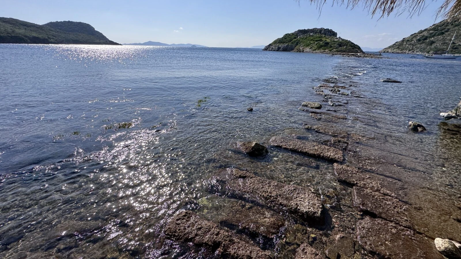 A view of the historical city wall remnants extending to Rabbit Island in Bodrum, Mugla, revealed by the receding Aegean Sea.