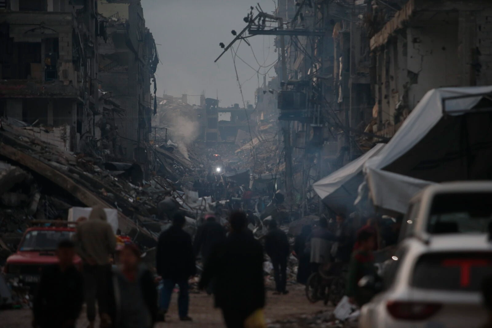 Photo shows people among the rubbles.