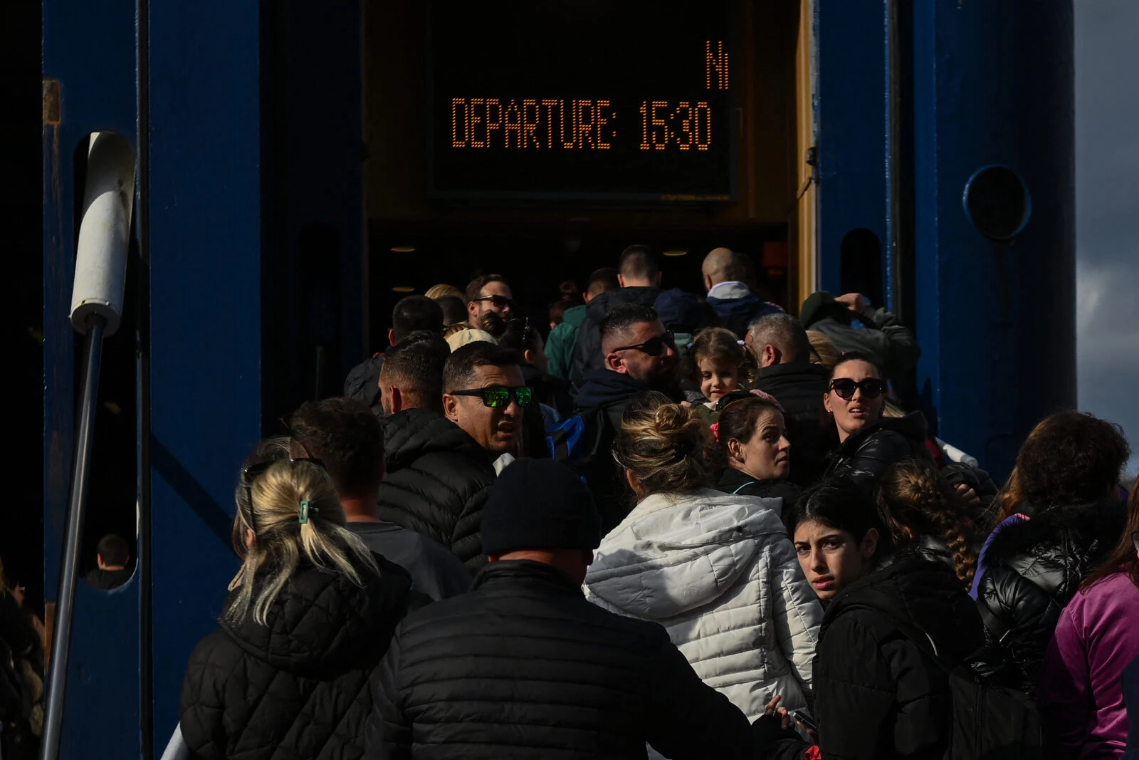 People embark a ferry at the port on the Greece