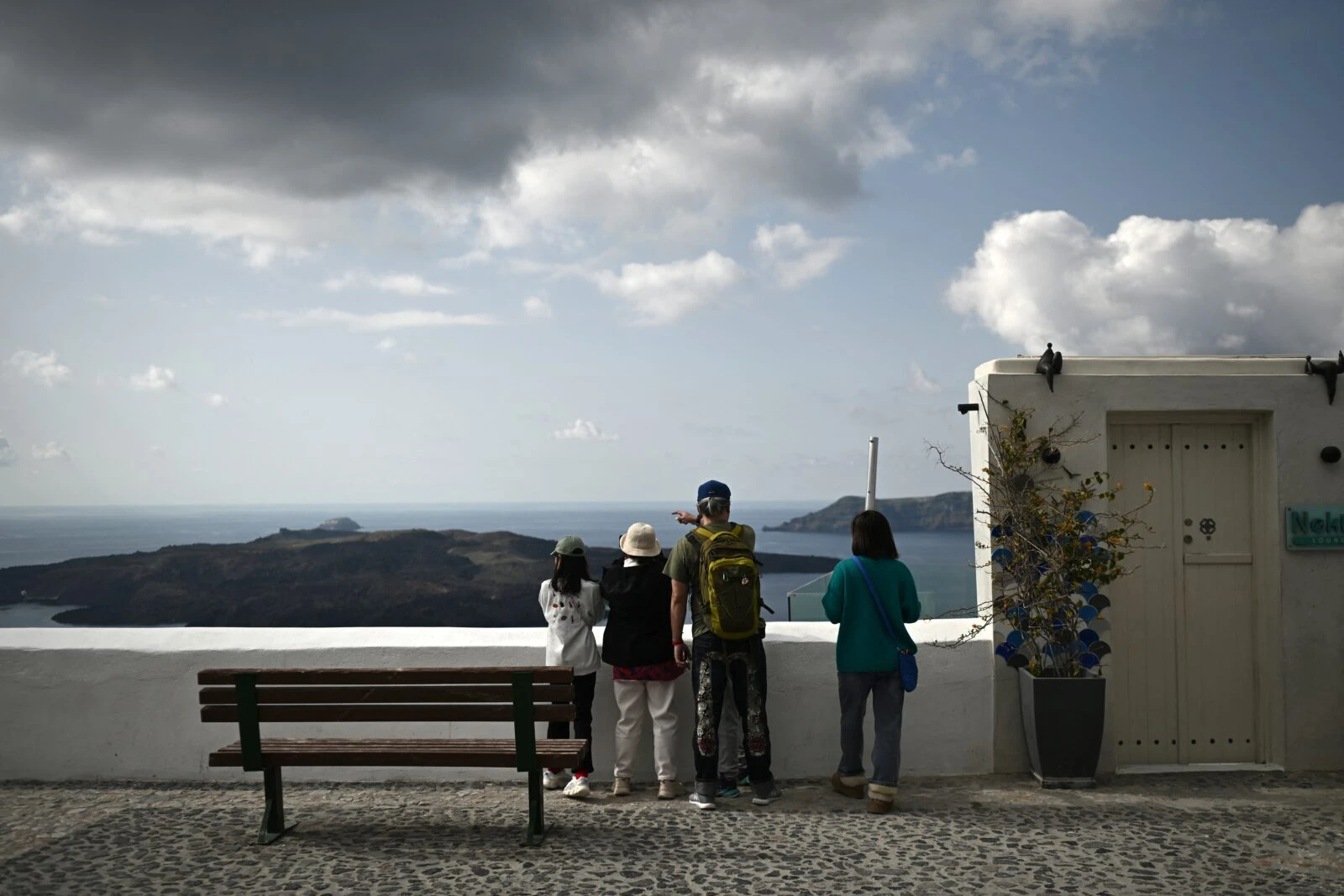 Bystanders look out over the sea from a point in Fira