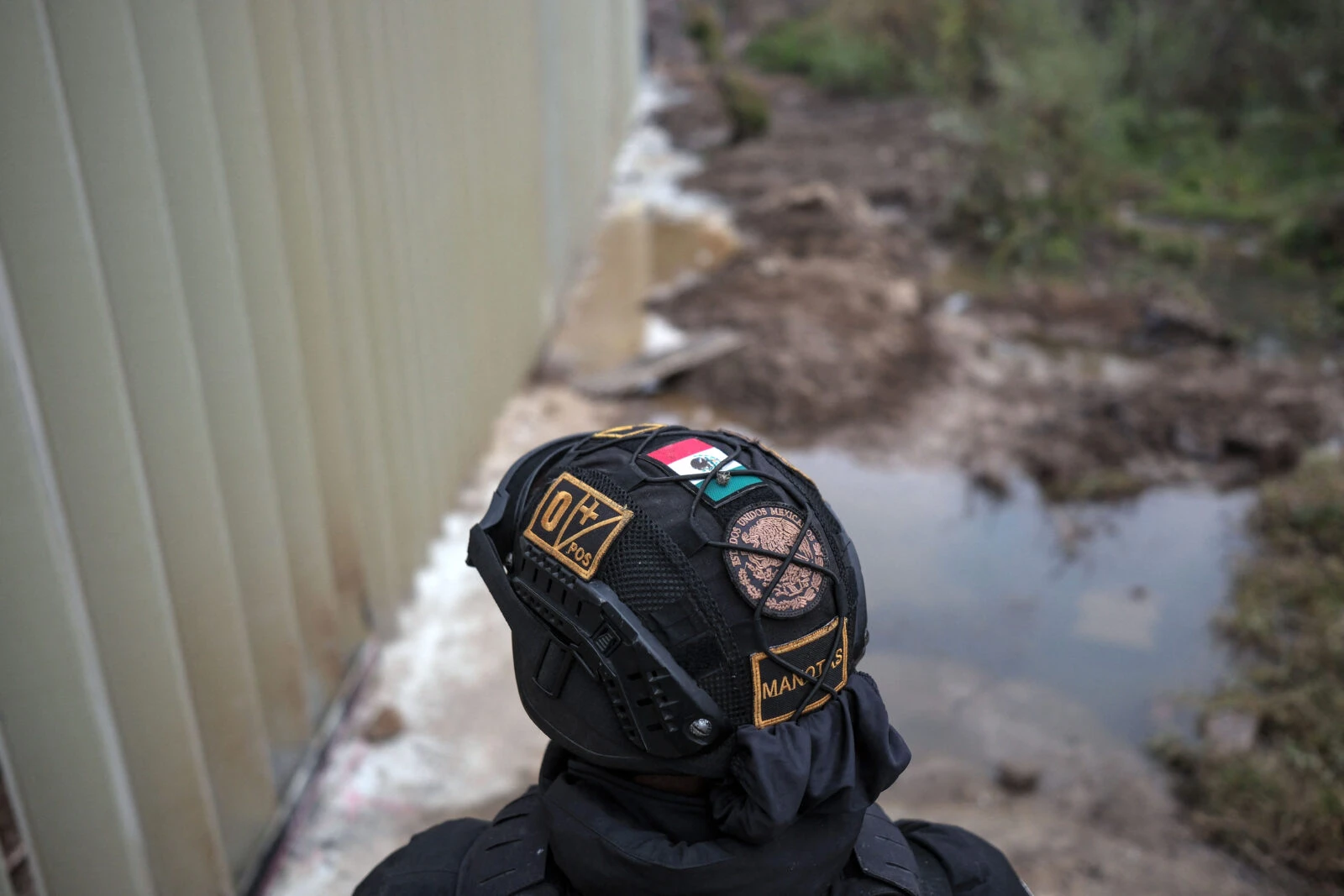 Photo shows mexico soldier looking at US border wall 