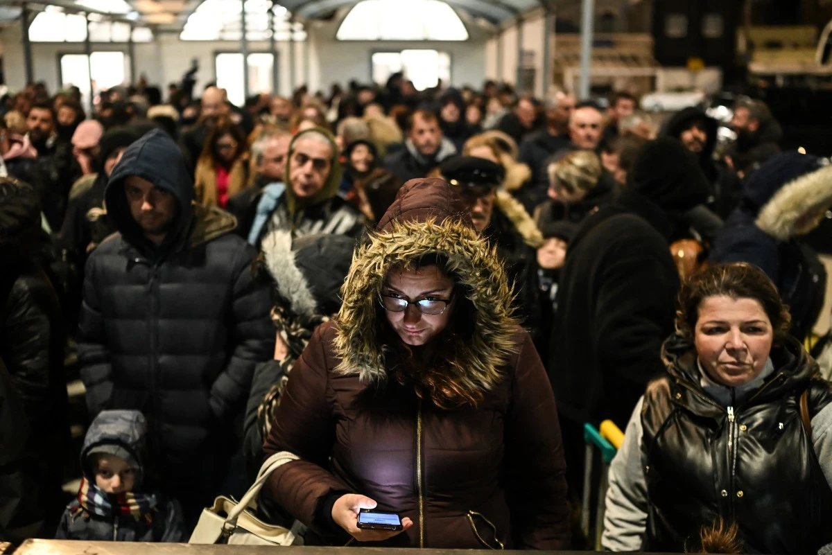 People standing in a queue on the ferry platform in Santorini, Greece, waiting to board as a result of recent earthquakes.