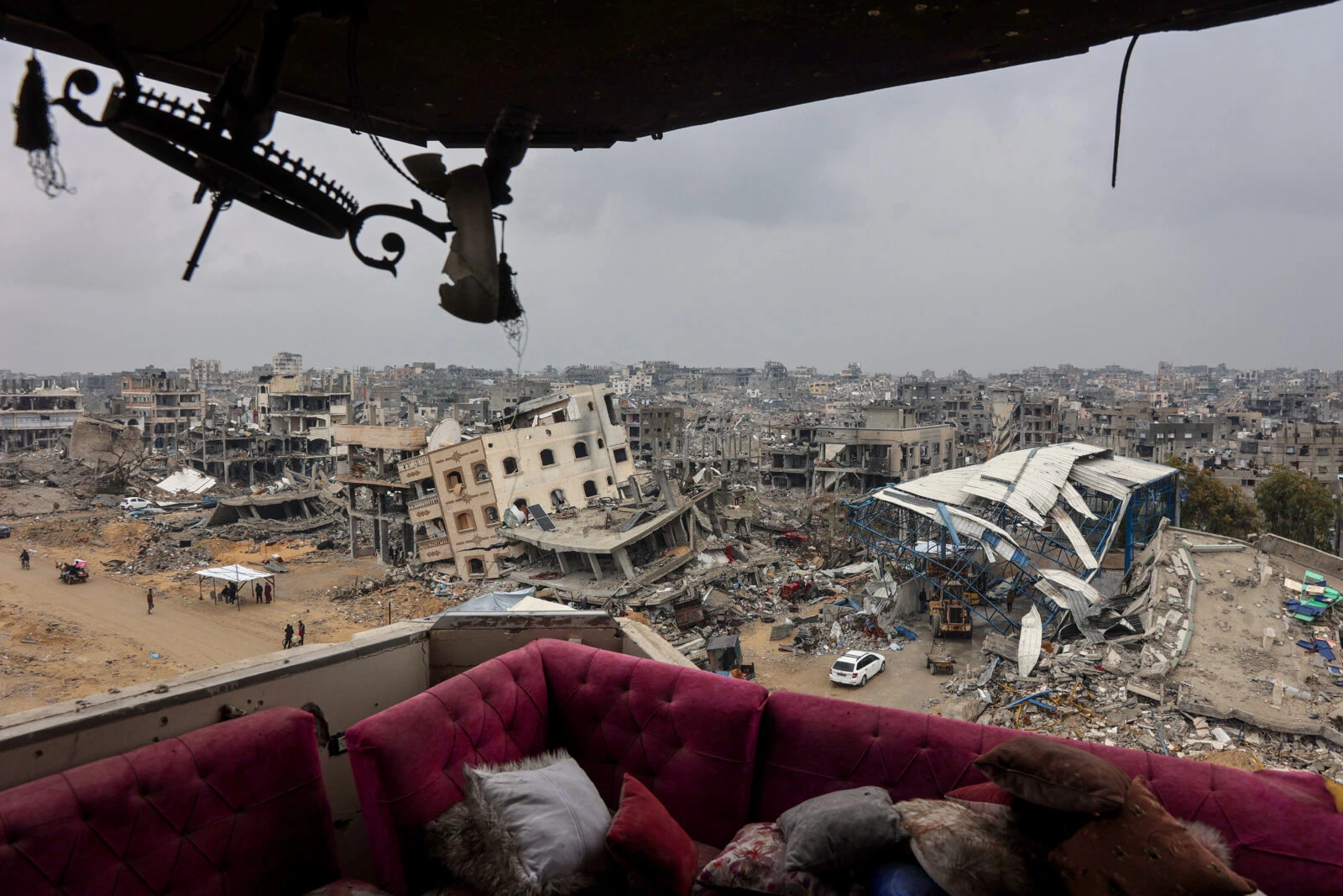 A couch sits at a heavily damaged building