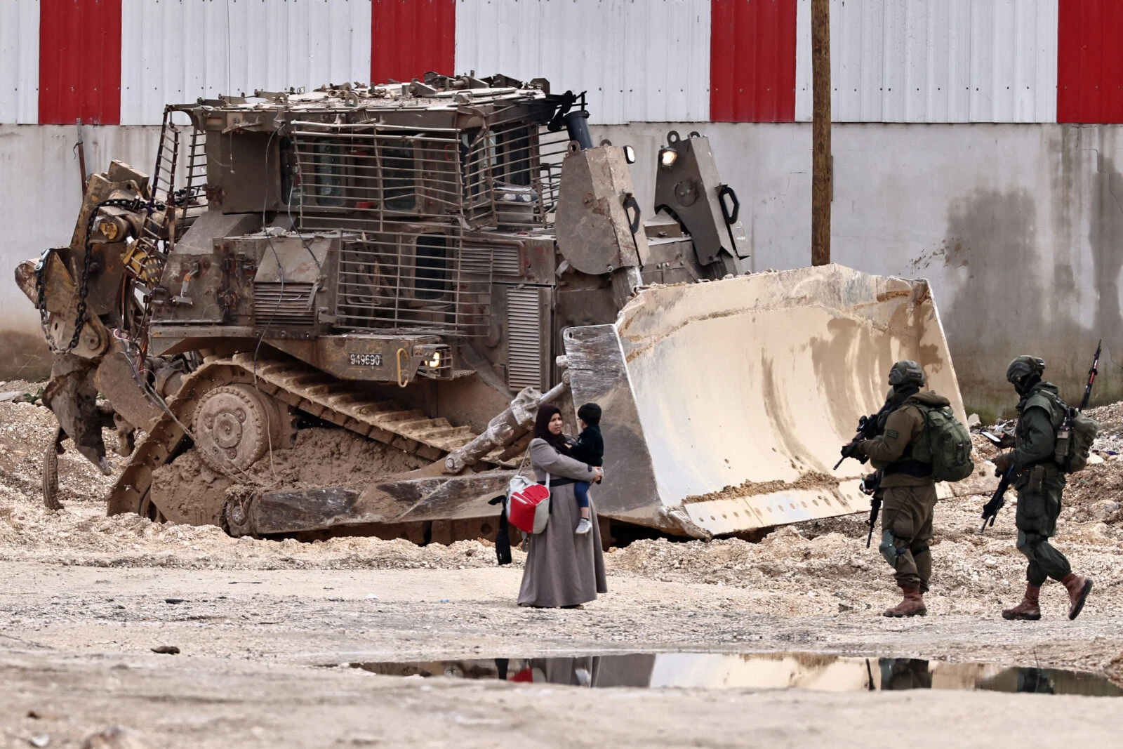 Israeli soldiers speak with a Palestinian woman 