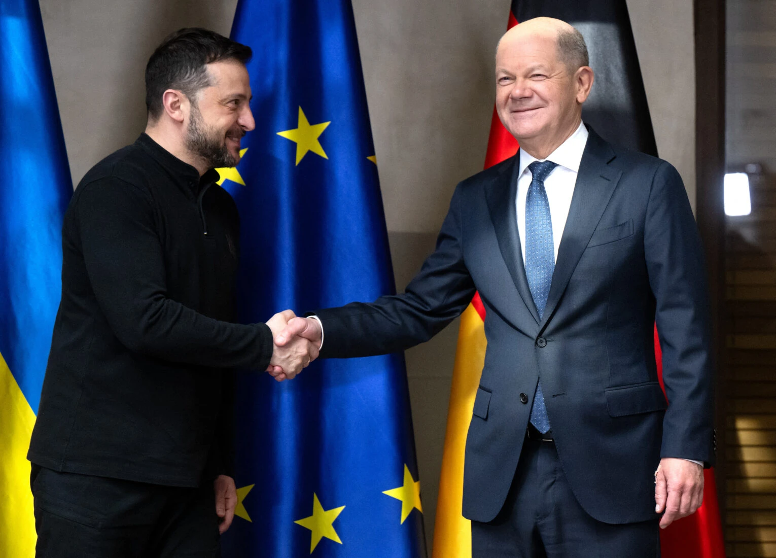 German Chancellor Olaf Scholz (R) shakes hands with Ukrainian President Volodymyr Zelensky 