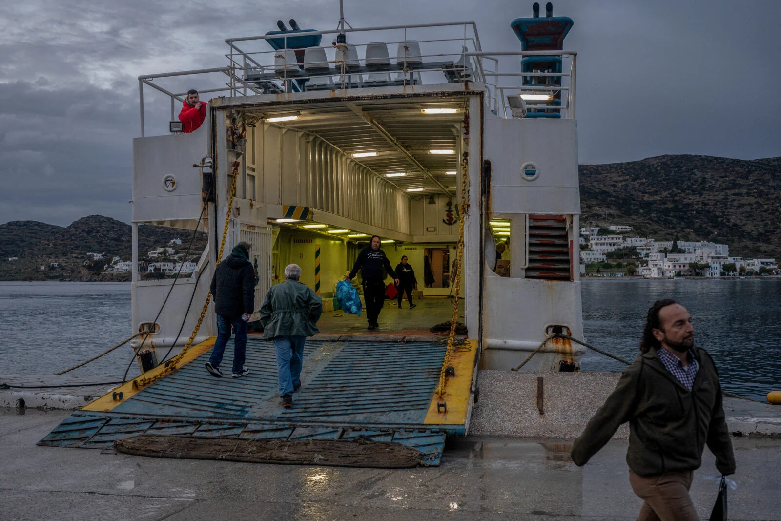 People receive their parcels from the staff of the Skopelitis ferry ship at the port of Katapola, on the Greek island of Amorgos