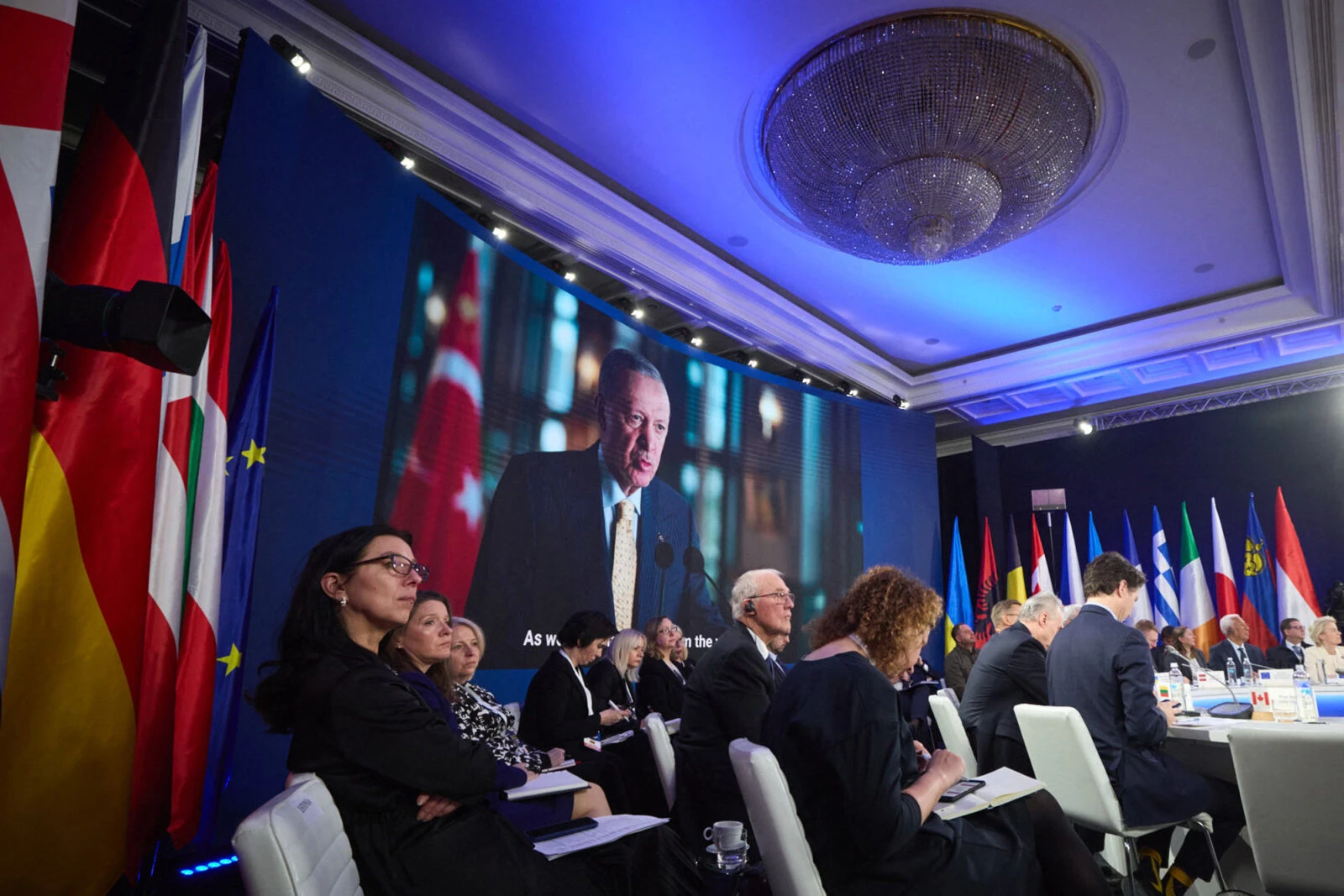 Photo shows peopele listening to Turkish President Erdogan.