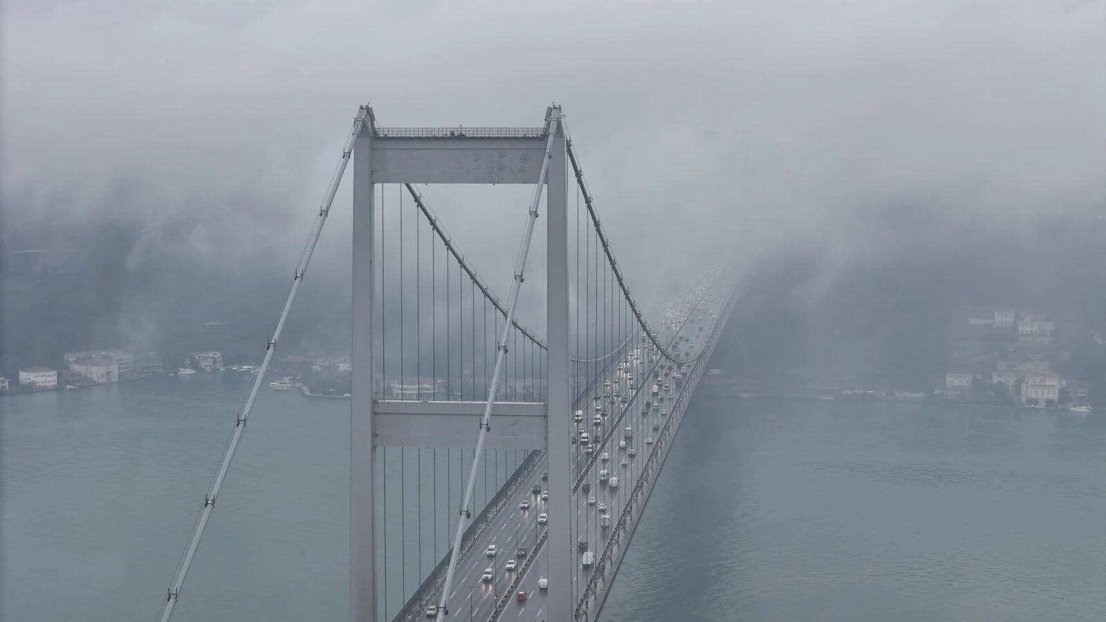 A drone captures the 15 July Martyrs Bridge partially veiled in dense fog over the Bosphorus