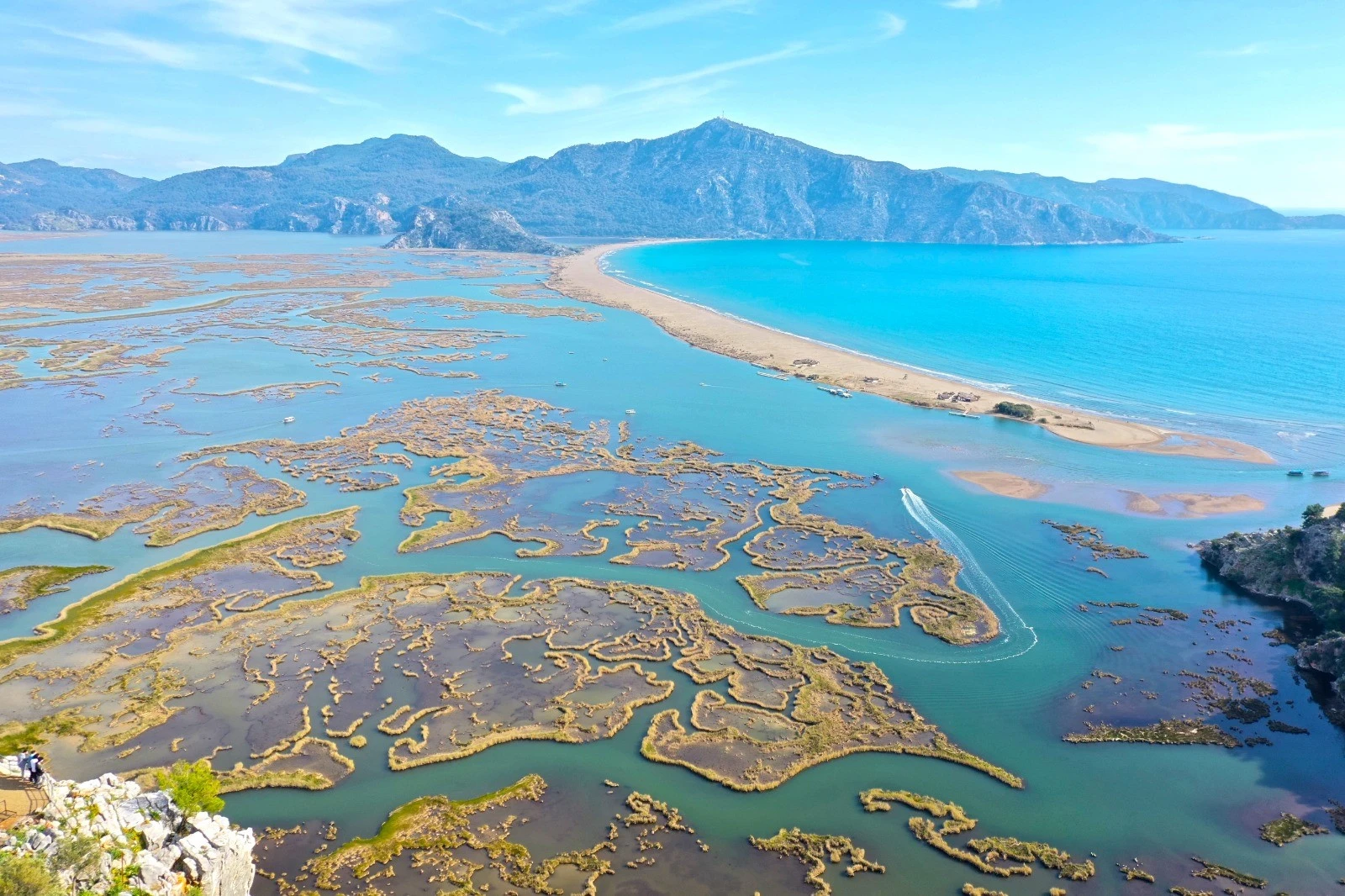 An aerial photograph showcasing the stunning İztuzu Beach in Muğla, Türkiye, where golden sands meet the turquoise waters of the Mediterranean.