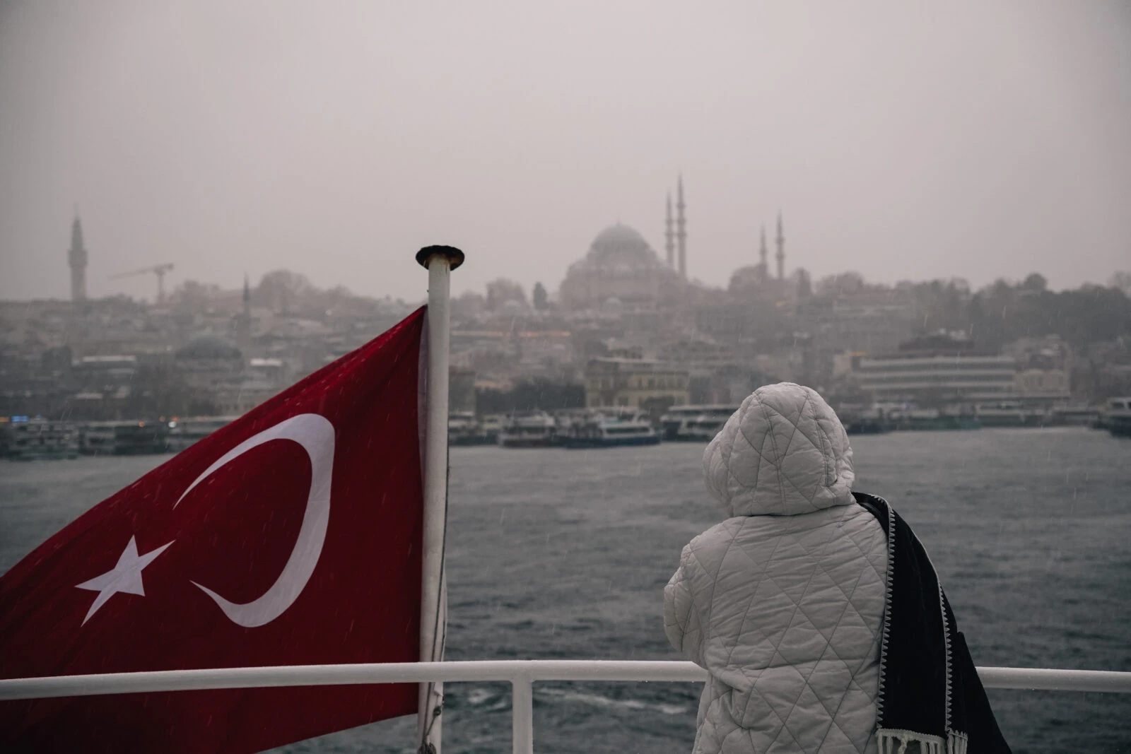 A tourist stands on a ferry deck