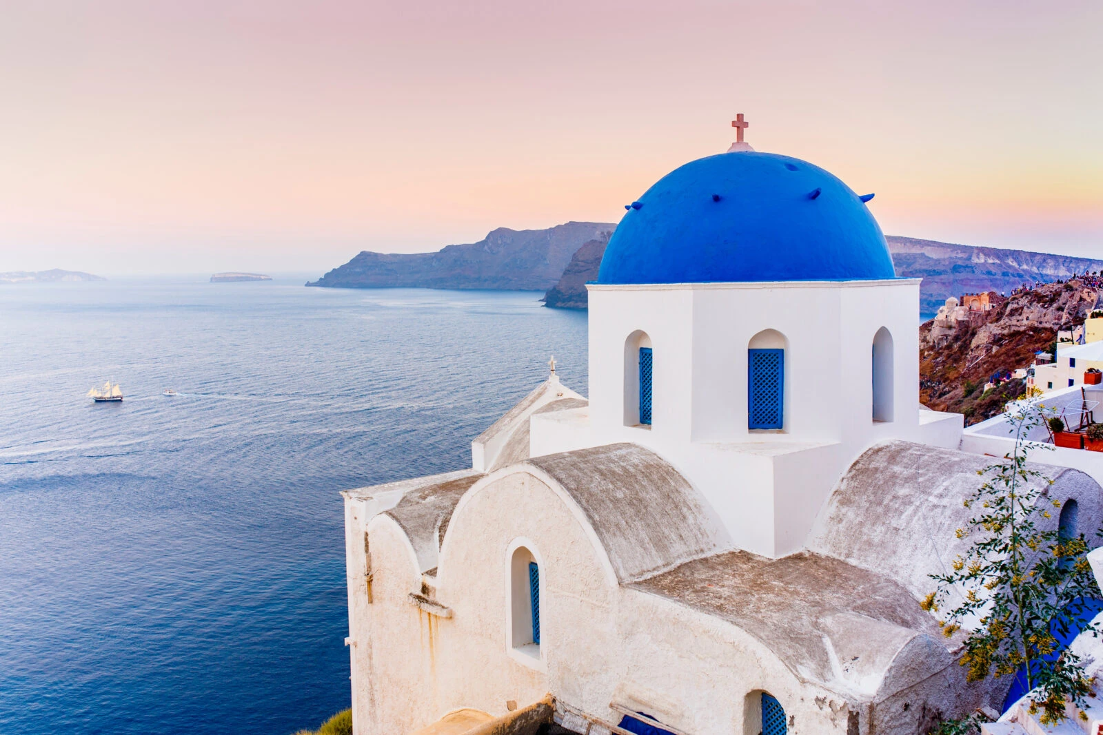 Picturesque view of Old Town Oia on the island Santorini, white houses, windmills and church with blue domes, Greece 