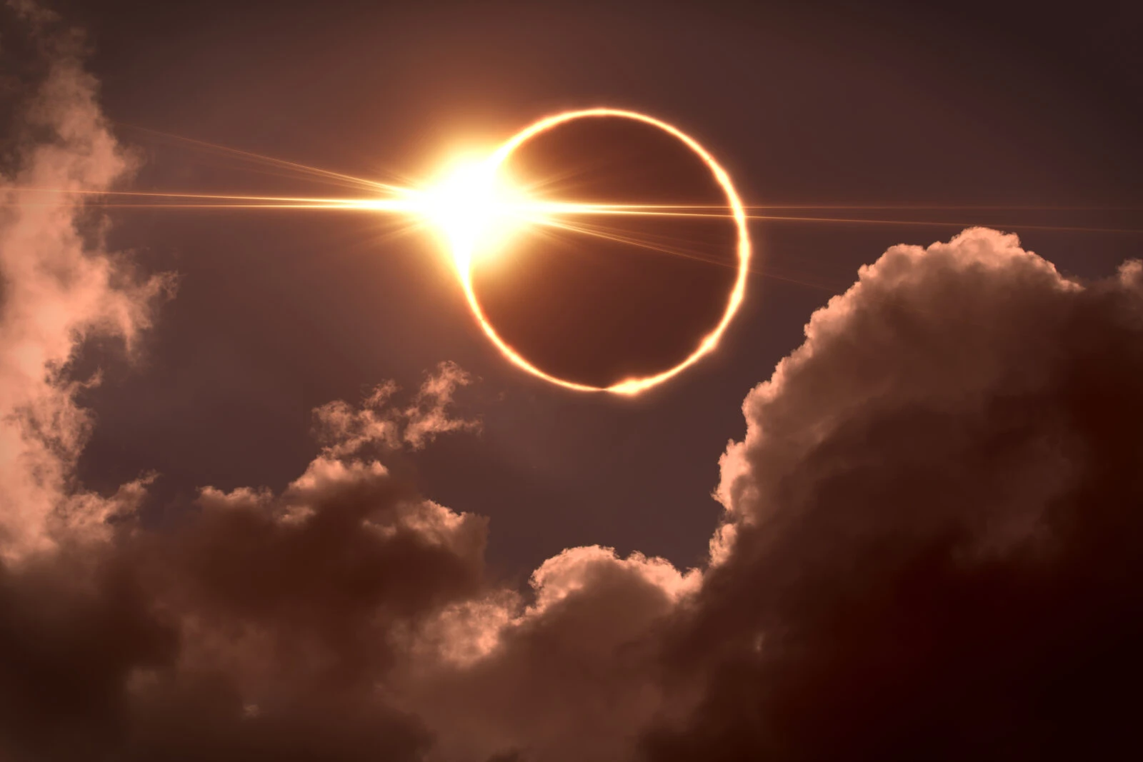 A dramatic image of a solar eclipse with a glowing ring of sunlight breaking through the darkness.