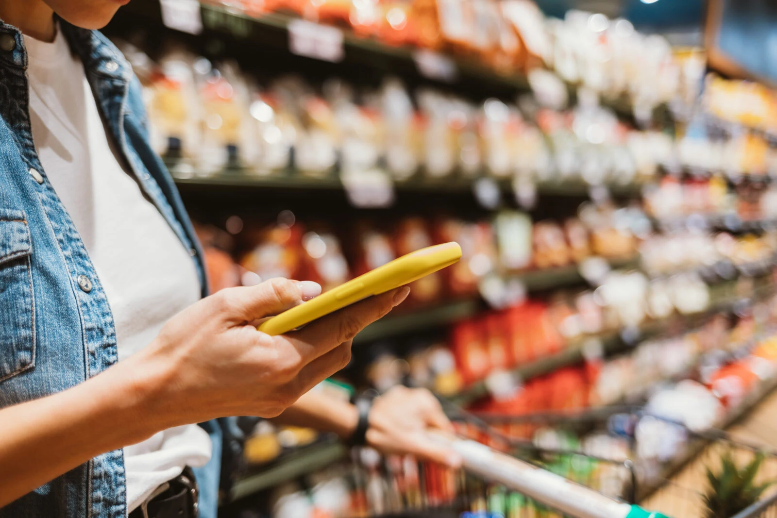 Mobile phone in female hands in a grocery store