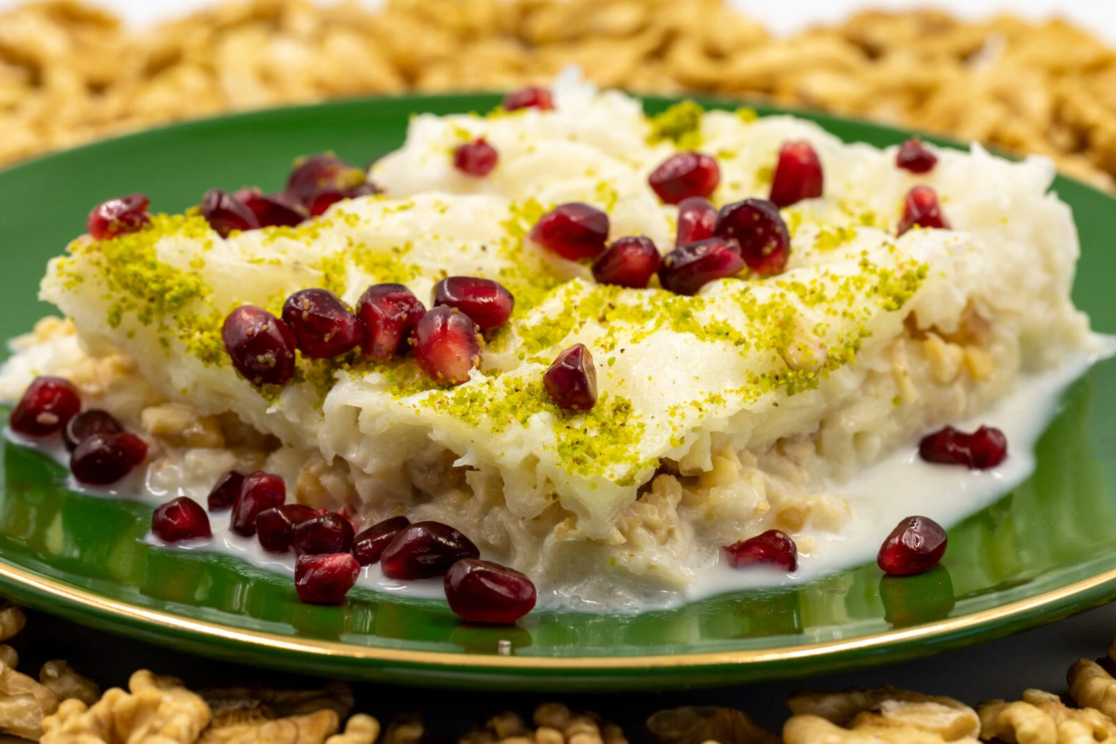 A plate of Güllaç, a traditional Turkish dessert made with thin layers of starch-based pastry, milk, walnuts, and pomegranate, served during Ramadan.