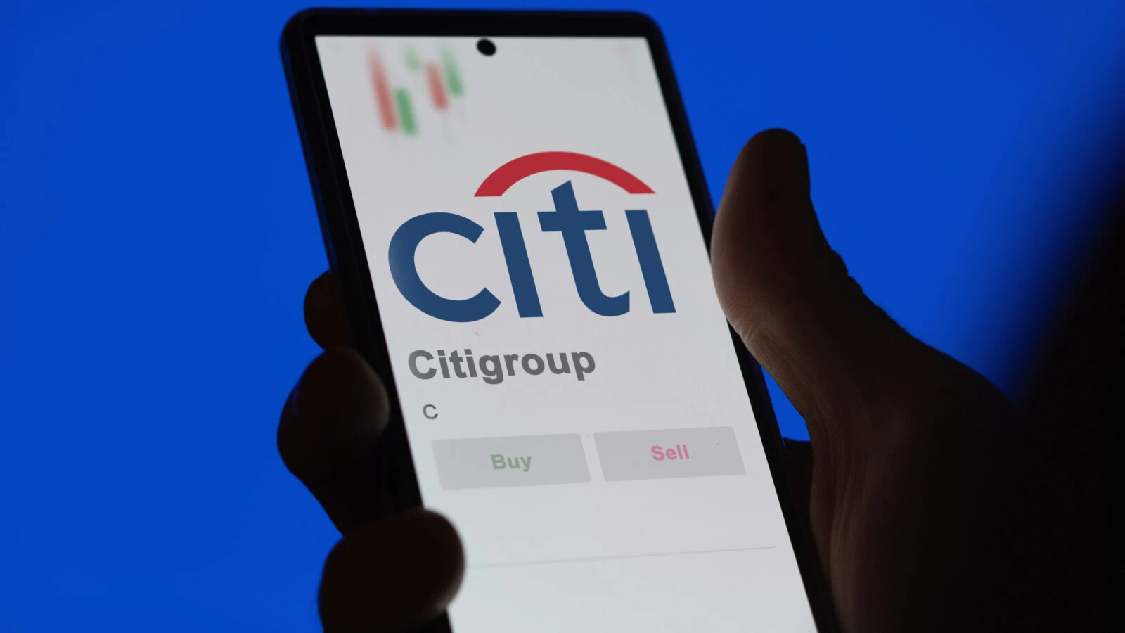 a person holding a smartphone displaying the Citigroup logo