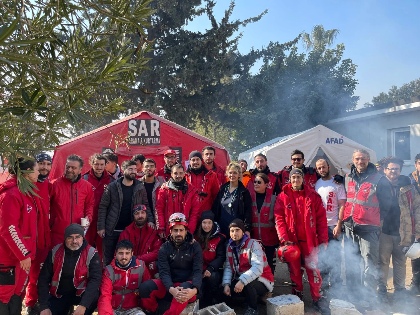 Volunteers and emergency workers gather in front of search and rescue base, showing the strength of teamwork in turkey