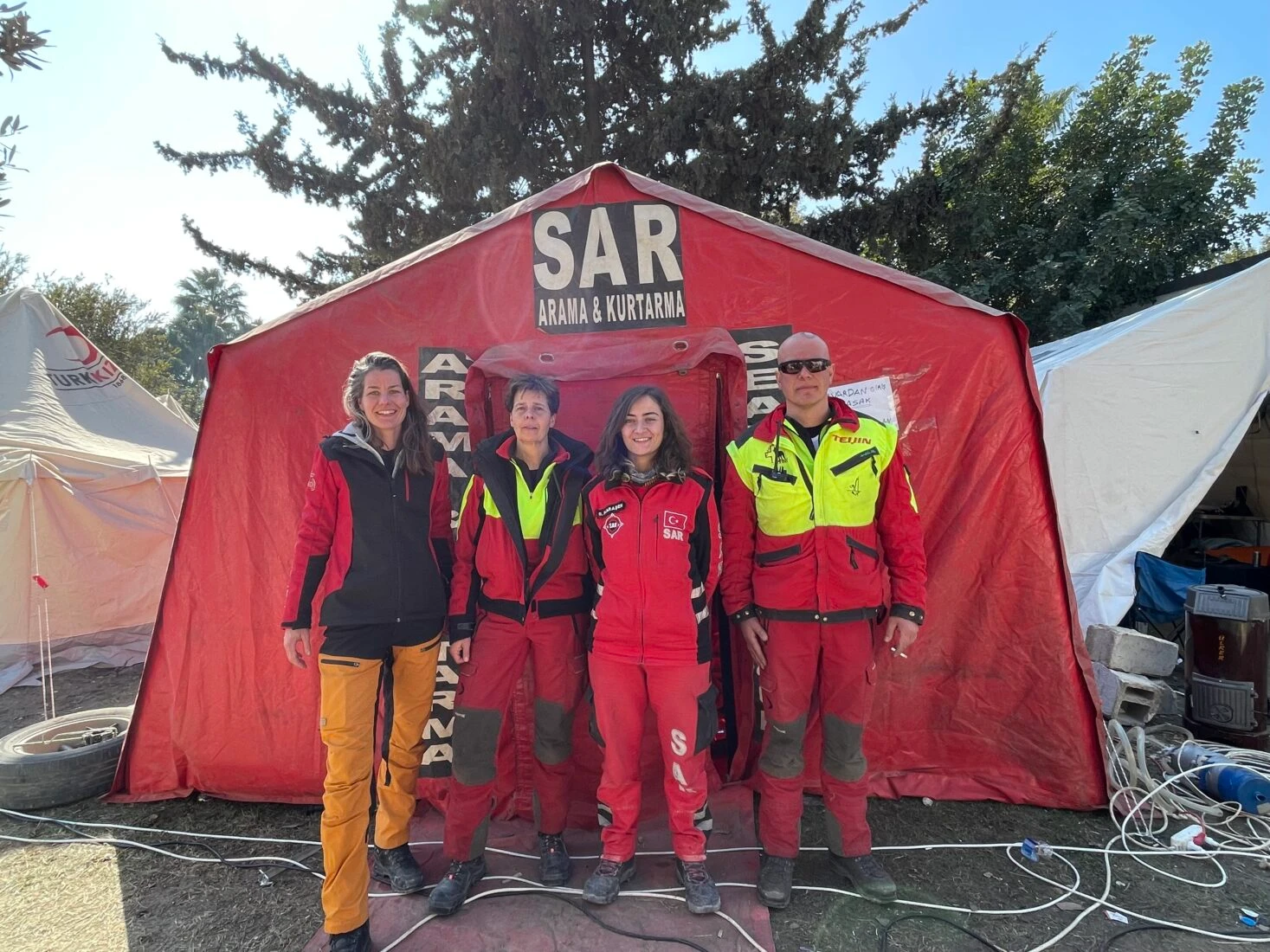 Search-and-rescue workers from Turkey and the Netherlands in front of a red SAR tent