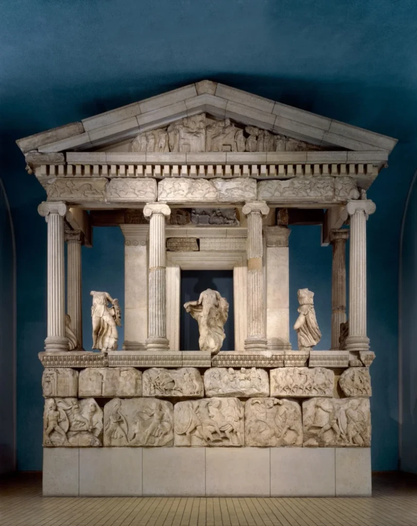 A detailed view of the Nereid Monument, an ancient Lycian tomb from Xanthos, Türkiye, now housed in the British Museum. The monument features ornate sculptures and columns, reflecting a blend of Lycian and Greek architectural styles.