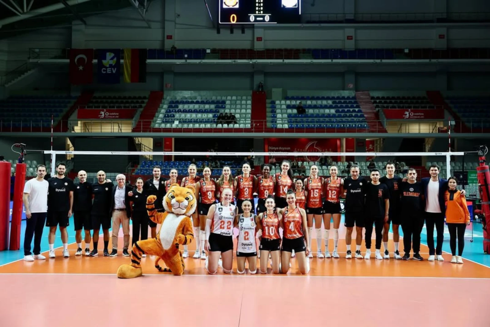 Eczacibasi Dynavit volleyball team posing on the court with their coaching staff and a team mascot after their match against Levallois Paris Saint Cloud in Türkiye, December 10, 2024