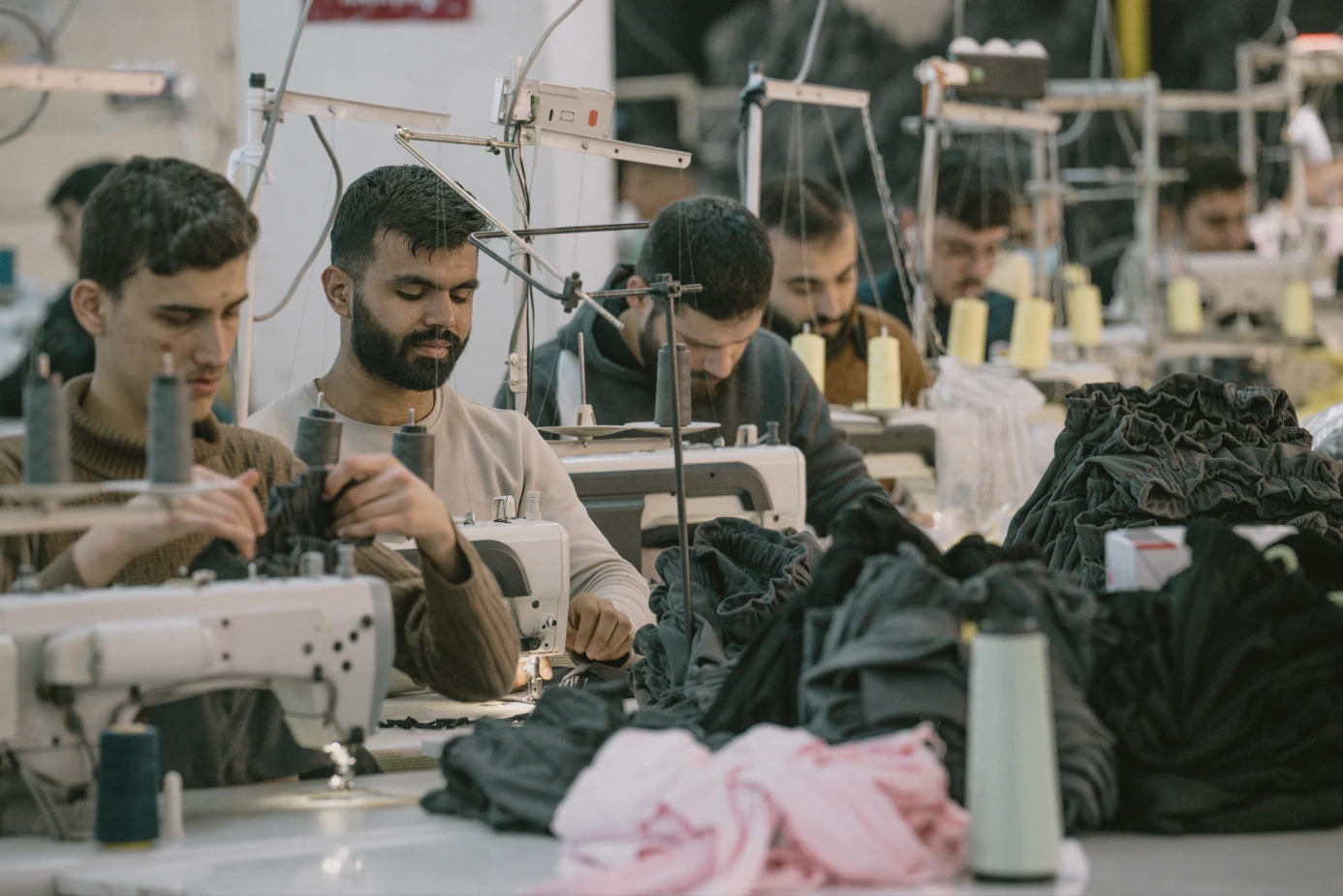 Photo shows syrian textile workers in Turkey operating sewing machines