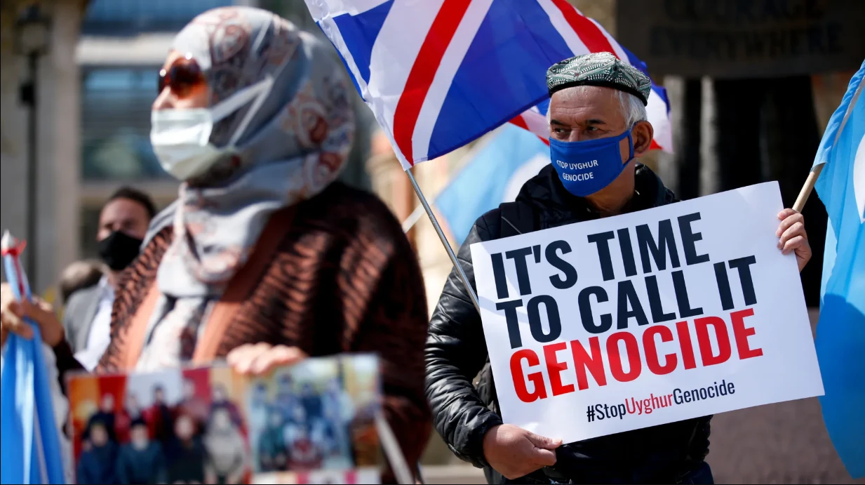 Photo shows uyghur diaspora carrying banner reading 'it's time to call it genocide #stopuyghurgenocide' 