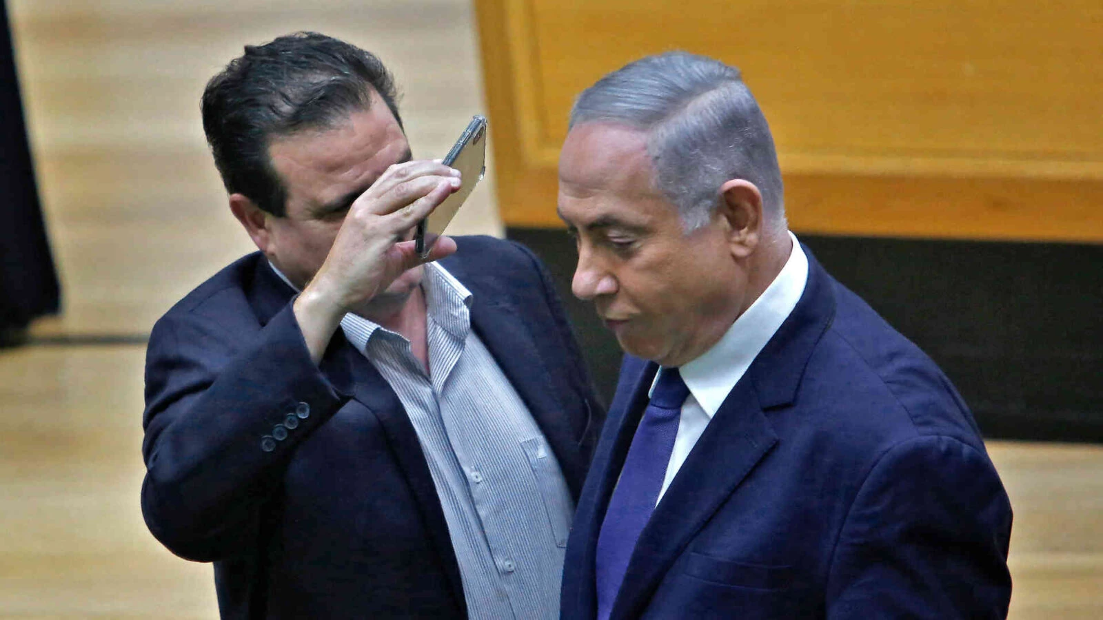 Knesset member Ayman Odeh uses a phone to take a close-up picture of Netanyahu