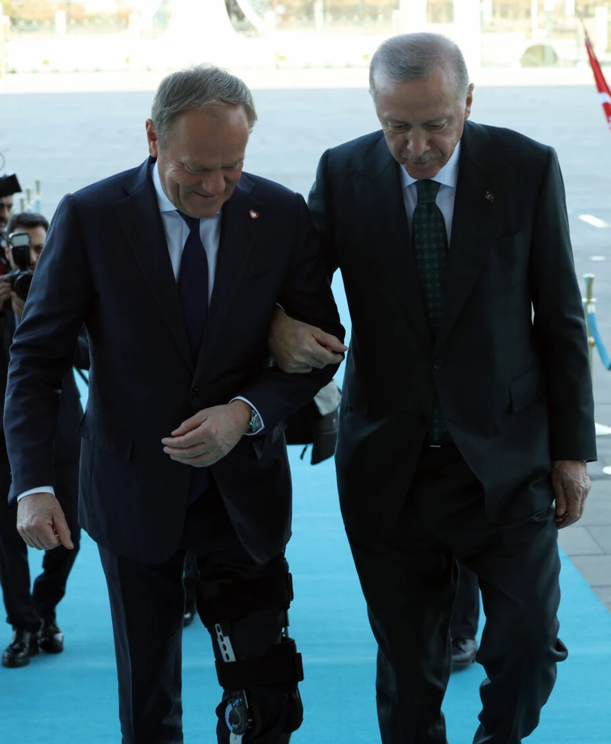 Photo shows Turkey's President Recep Tayyip Erdogan (R) assists Polish Prime Minister Donald Tusk (L).