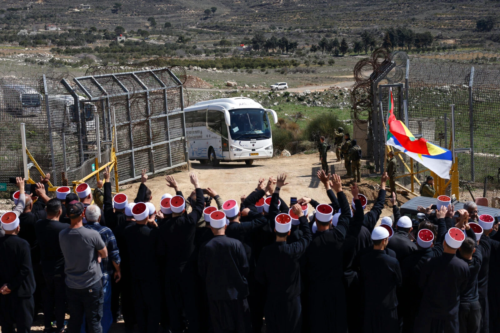 Druze men stand near a border barrier in the village of Majdal Shams