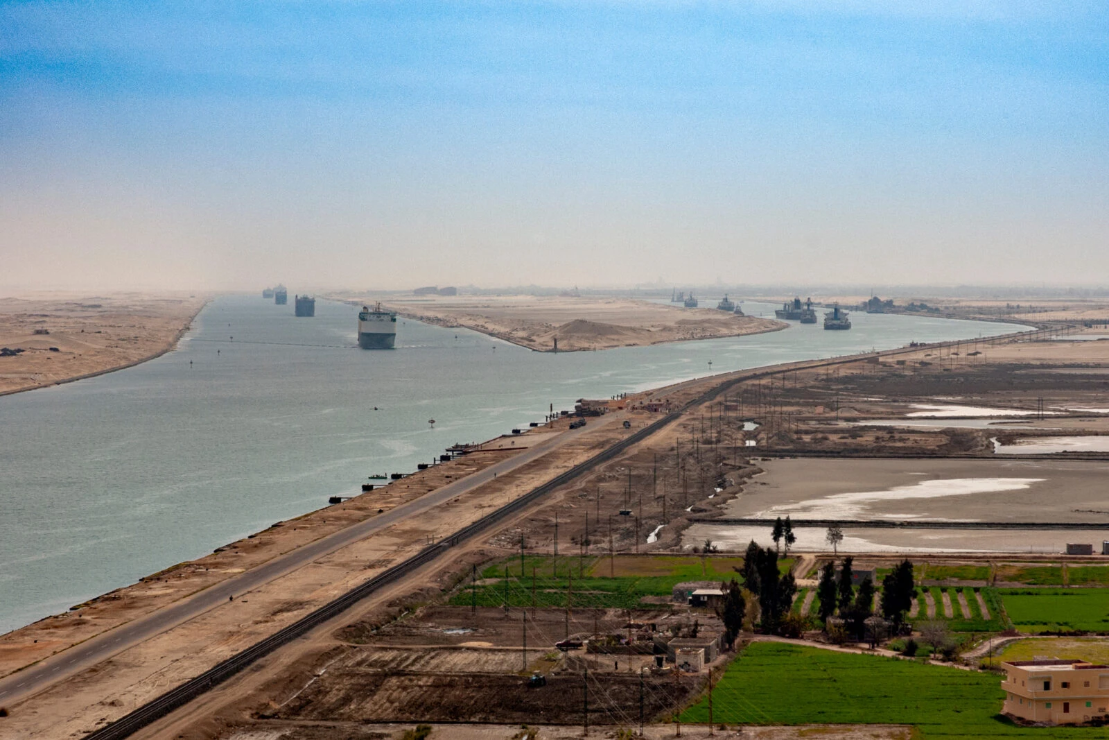 Cargo ships navigating the Suez Canal, desert in background