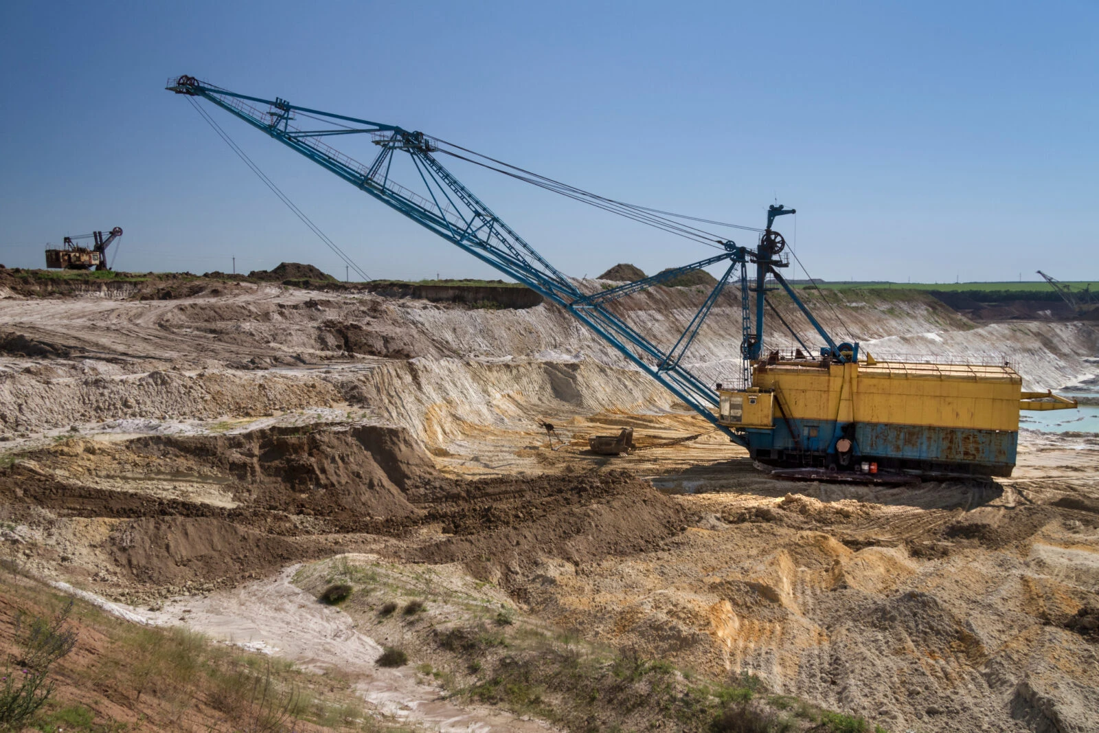 A walking dragline excavator performs overburden stripping