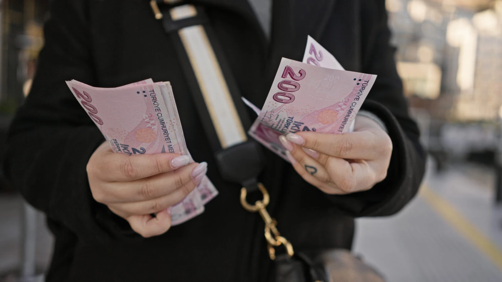 Woman counting Turkish lira banknotes on a Istanbul street