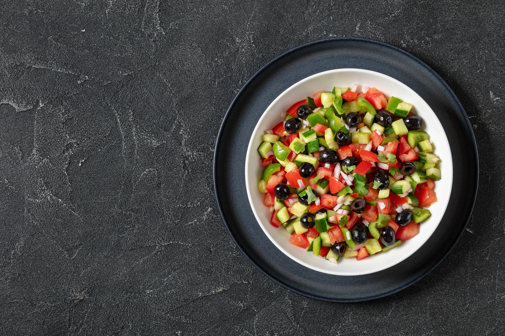 Turkish coban salatasi, a refreshing salad made with chopped tomatoes, cucumbers, green peppers, onions, and black olives.