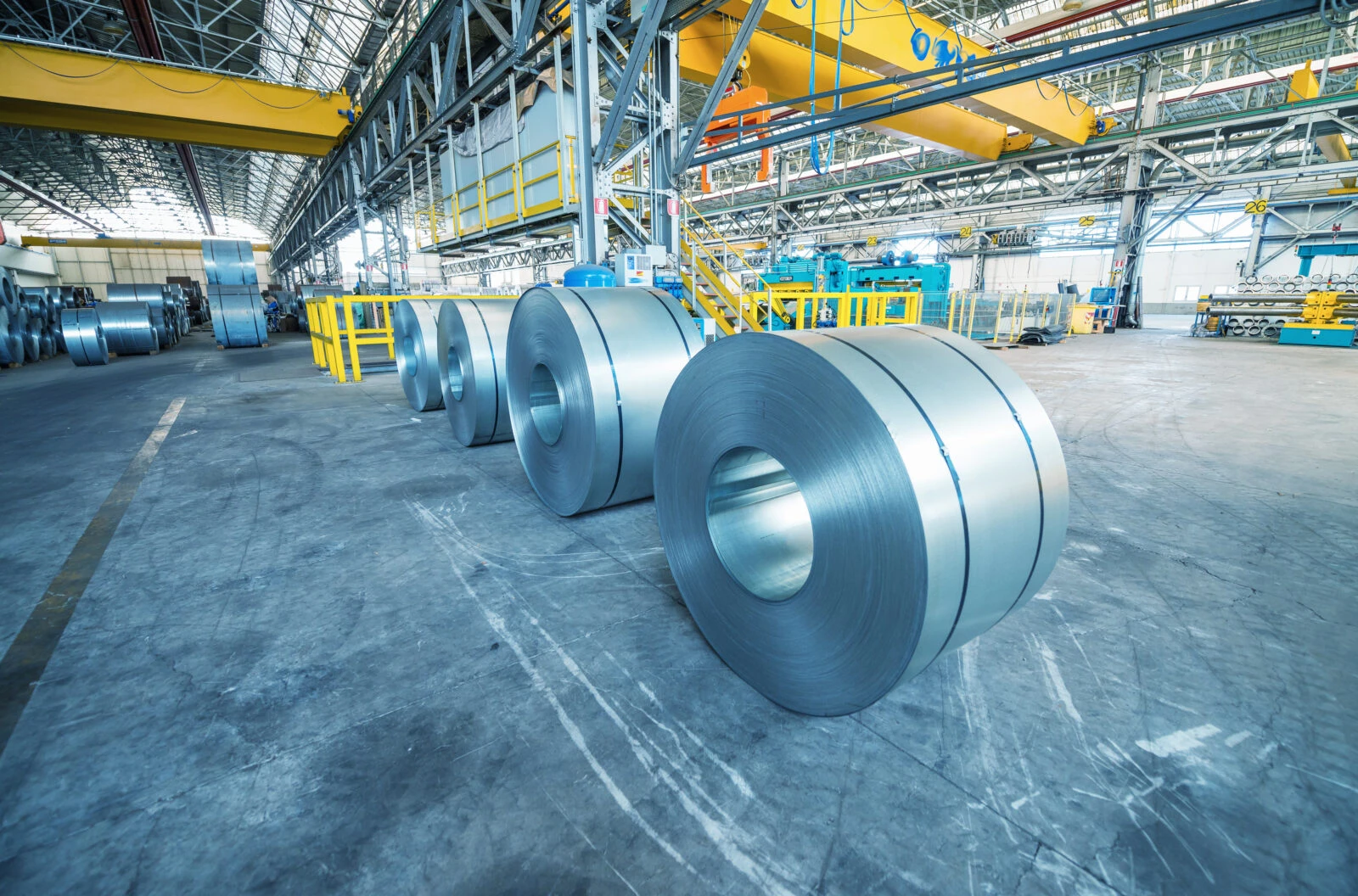 Cold rolled steel coils in storage area ready to feed to machine in metalwork manufacturing.