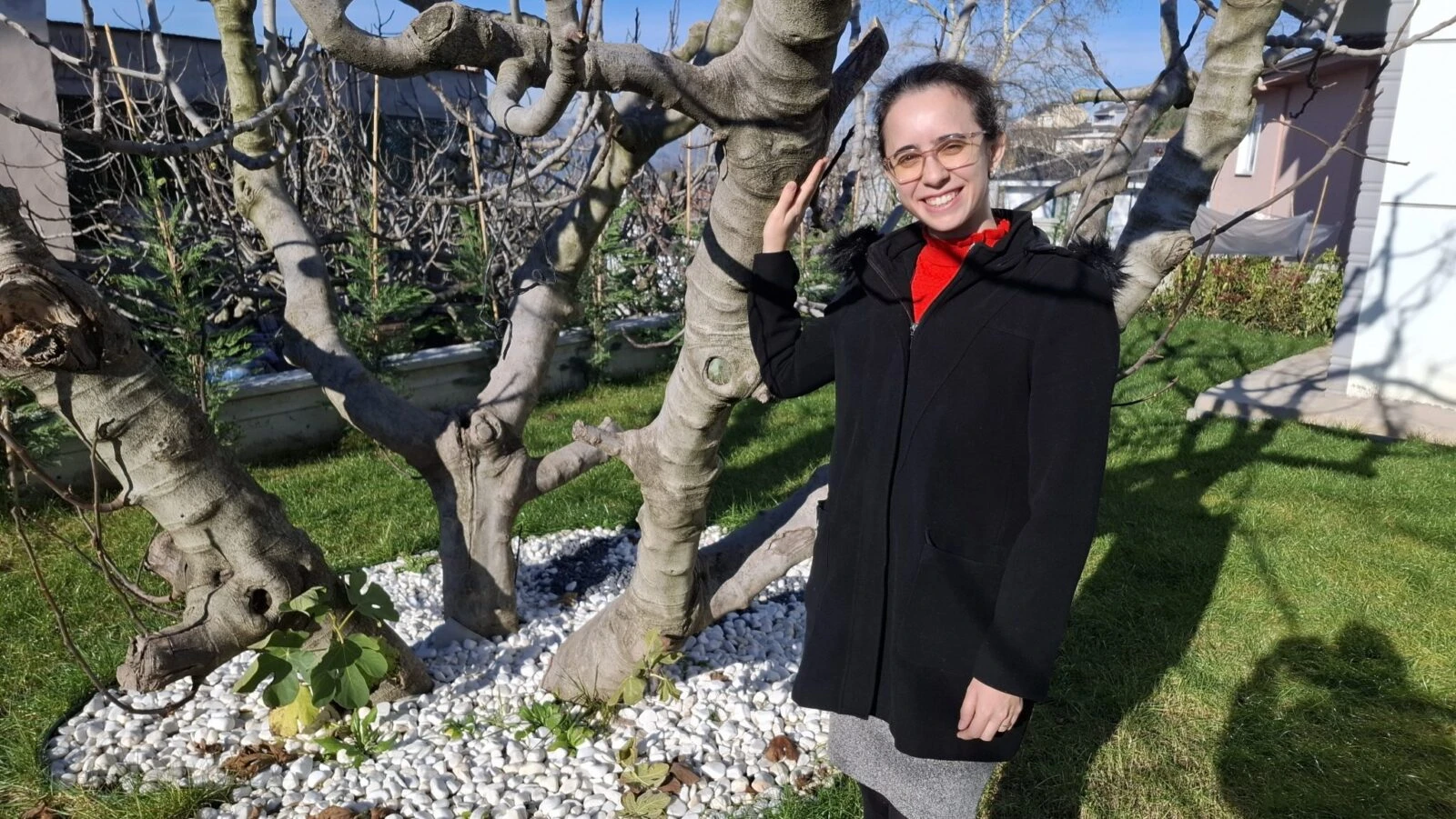 Sila Ozkan, a female black fig producer and agricultural engineer, standing next to a fig tree in Bursa, Türkiye.