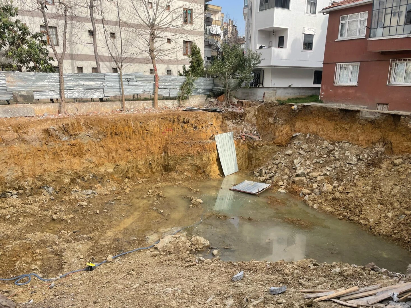 Water flooding the foundation of a demolished building in Istanbul, originating from the sewage connection, with no measures taken.