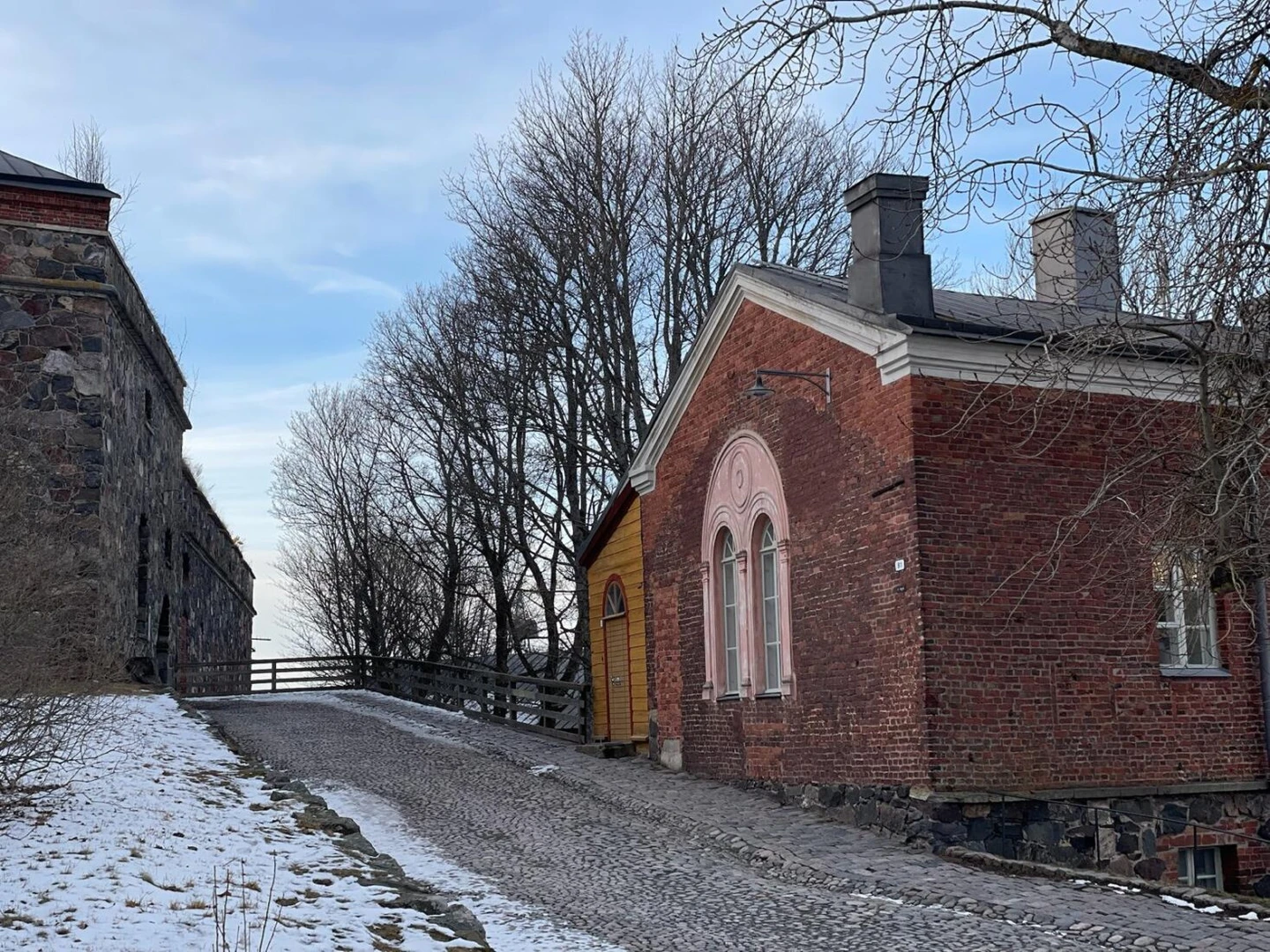 Colorful traditional houses on Suomenlinna Island, Finland, with a peaceful winter atmosphere.