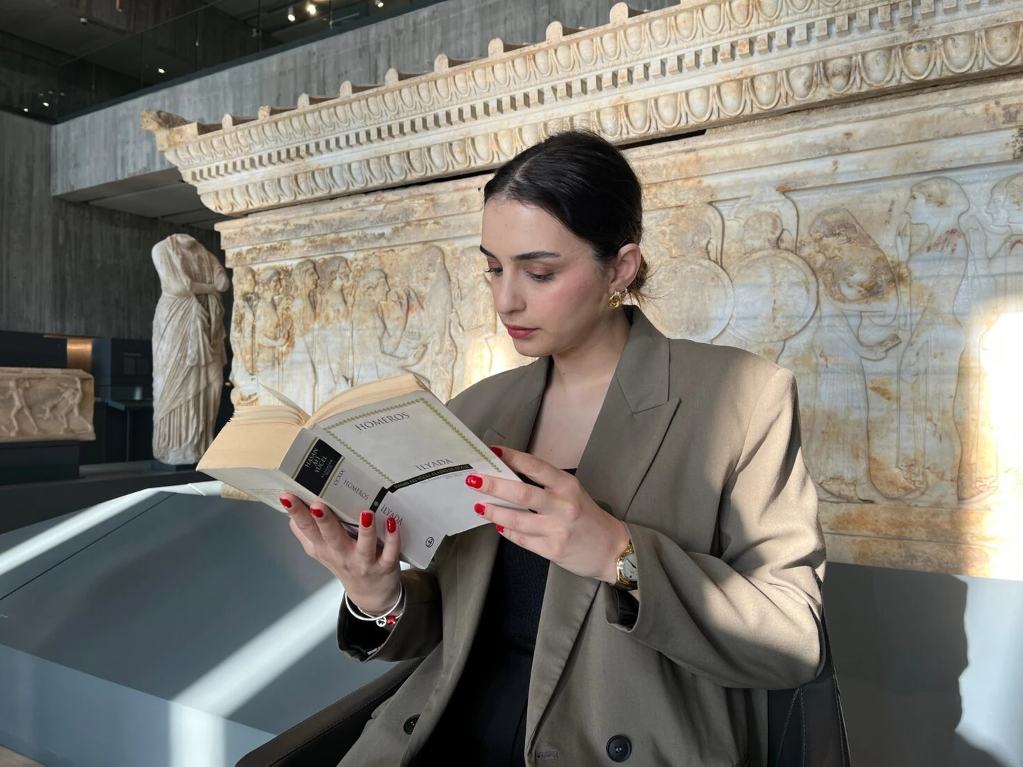 A participant reading Homer's Iliad in front of the Polyxena Sarcophagus.